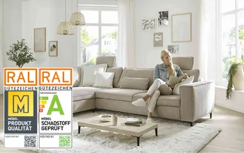 Frau sitzt auf bequemen Sofa und liest Zeitschrift